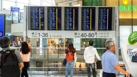 공항 출발 안내판 앞의 여행객들