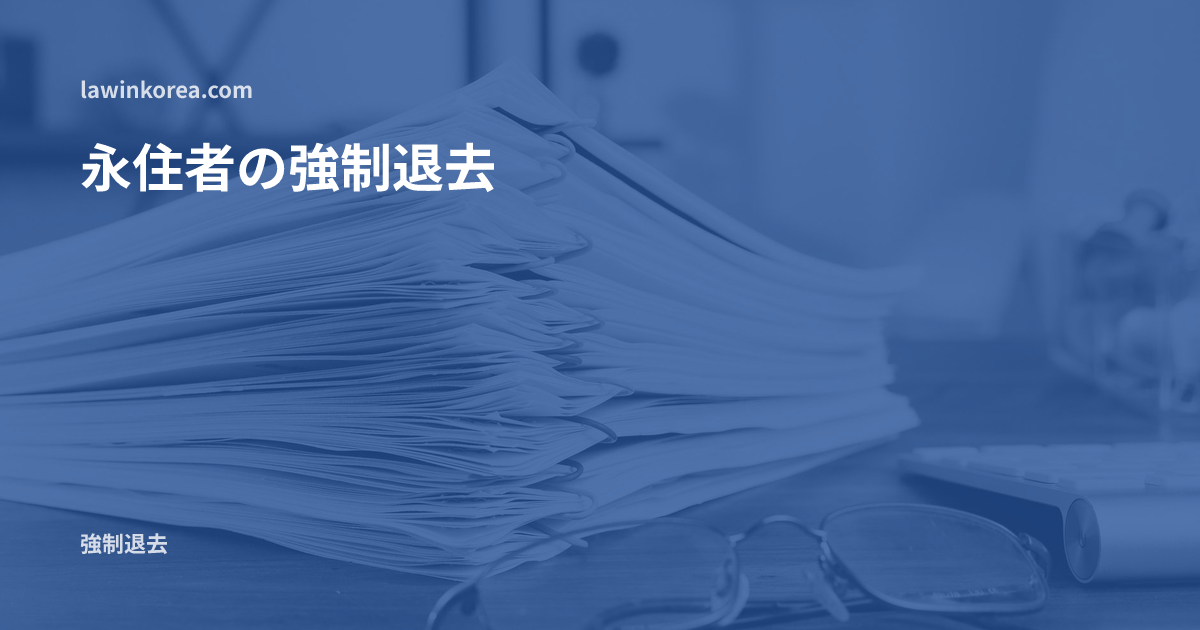 眼鏡とともに机の上に積まれた書類の束: 永住者(F-5)も強制退去されるのか — 例外事由と永住資格取消しの違い
