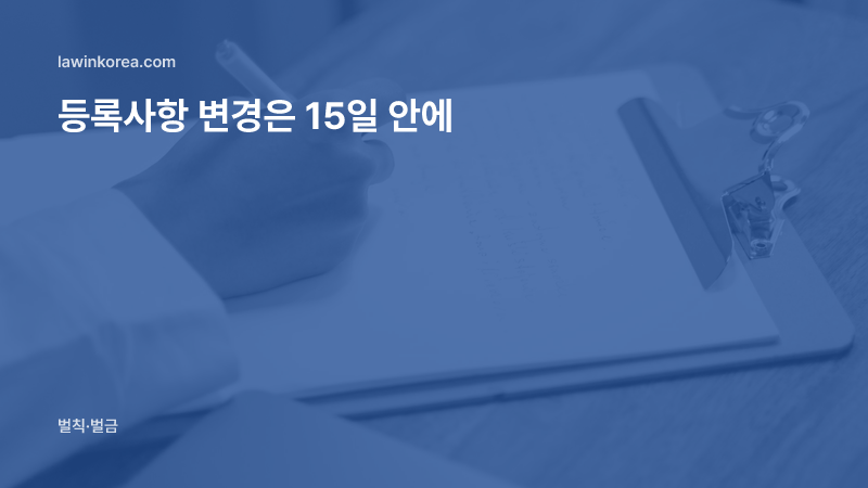 나무 탁자 위 클립보드에 글을 쓰는 손: 여권을 새로 받았어요 — 외국인등록사항 변경신고 15일, 늦으면 과태료
