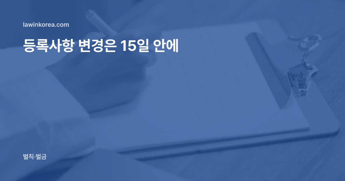 나무 탁자 위 클립보드에 글을 쓰는 손: 여권을 새로 받았어요 — 외국인등록사항 변경신고 15일, 늦으면 과태료
