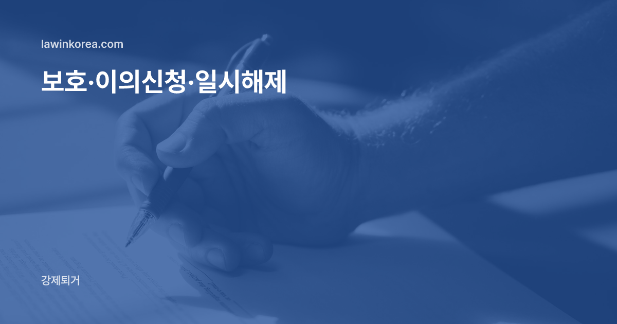 파란 펜으로 서류에 서명하는 손: 출입국 보호(구금)된 외국인, 이의신청·심사청구·일시해제는 어떻게 하나요?