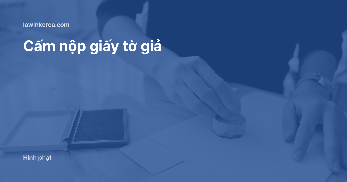Bàn tay đóng dấu lên giấy tờ trên bàn gỗ: Nộp giấy tờ giả mạo hoặc khai gian khi xin phép lưu trú: xử phạt theo Điều 26 và nguy cơ buộc xuất cảnh