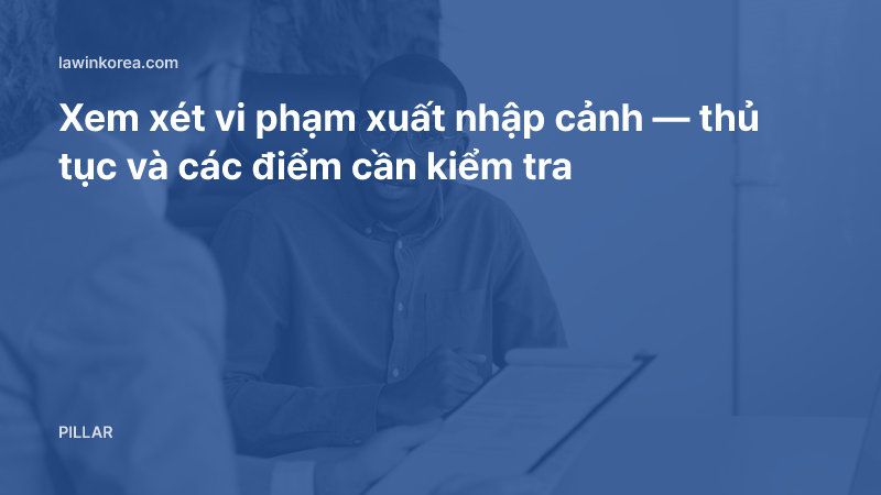 Ảnh hai người trao đổi giấy tờ trong văn phòng: Xem xét vi phạm xuất nhập cảnh — thủ tục và các điểm cần kiểm tra